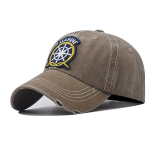 Close-up of khaki washed cotton baseball cap featuring vintage distressed brim and marine embroidery