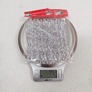 Pink icicle Christmas ornaments weight detail on a scale in original packaging
