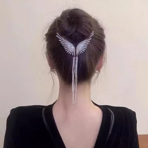 Elegant silver wing hair claw with rhinestone tassels on a minimalist bun hairstyle