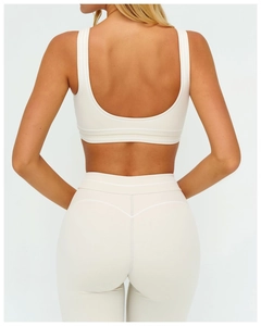 U-shaped open back detail of cream yoga sports bra and high-waisted fitness leggings