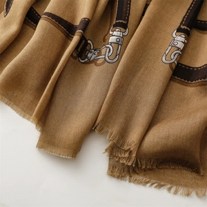 Close-up of camel cotton-linen scarf featuring brown belt pattern and fringe details