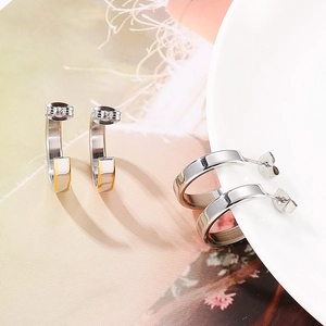 Detailed view of geometric C-shaped stainless steel earrings in gold and silver finish