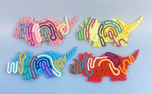 Vier bunte Silikon-Sensorik-Boards in Dinosaurierform in Rosa Gelb Blau und Rot