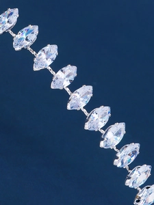 Macro shot of sparkling zircon leaf details on a silver metal headband for weddings