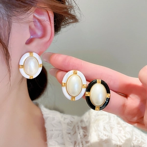 Close-up of vintage-style light luxury earrings in black and white worn by a model