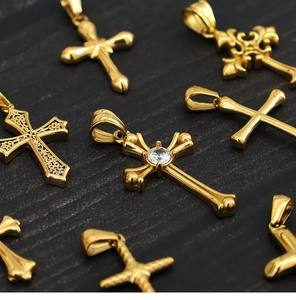 Macro view of gold plated titanium steel cross pendants with inlaid diamonds and engravings