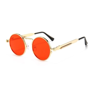 Detail of round steampunk sunglasses with gold metal frames and orange lenses