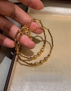 Detailed close-up of 18K gold-plated bamboo joint bracelets with sparkling zircon spheres