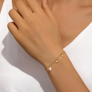 Detailed shot of s925 silver bracelet featuring pink pearl, heart, and moon charms on wrist