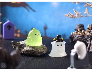 Glow in the dark Halloween ghost figurines featuring translucent green and white designs