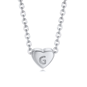 Macro shot of silver heart pendant with letter G engraving on stainless steel chain