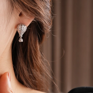 Gros plan macro d'une boucle d'oreille montgolfière en argent avec zircons brillants