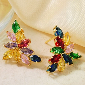 Macro shot of colorful marquise-cut gems set in a gold leaf-shaped floral stud earring