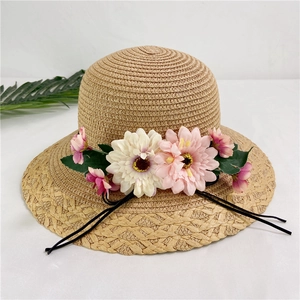 Detailed straw sun hat texture featuring large floral decorations and black tie strap