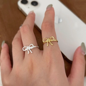 Minimalist S925 sterling silver bow knot rings in gold and silver finish shown on hand