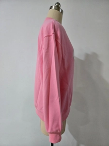 Vue latérale du sweat à col rond rose avec texture de tissu en coton tricoté doux