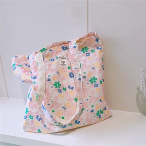 Close-up of floral cotton tote bag featuring a pink background and delicate blue blossoms