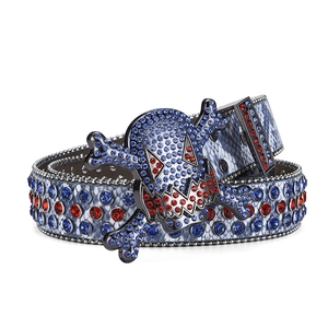 Detail of snake skin texture belt with skull buckle and blue and red rhinestones