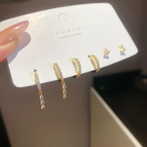 Detailed view of gold tassel earrings and zircon hoops displayed on jewelry card