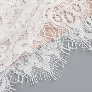 Gros plan détaillé sur dentelle blanche à cils avec doublure rose et broderie fine