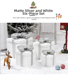 Detail of frosted silver white Christmas gift boxes with glitter bows on snowy background