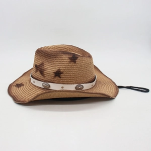Close-up of woven straw cowboy hat featuring star patterns and silver floral metal buckles