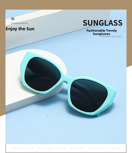 Close-up of mint green oversized cat eye sunglasses with dark polarized lenses