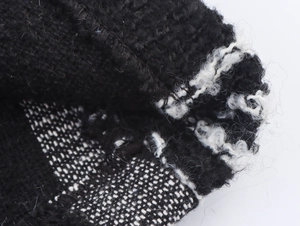 Detailed macro view showing the thick boucle knit texture and warm white lining of the coat