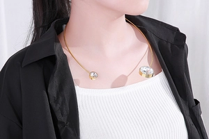 Close-up of golden stainless steel collar necklace with round zircon stone details