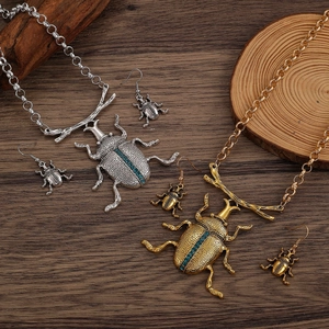 Dettaglio set gioielli scarabeo vintage con strass blu su fondo in legno
