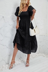 Detail of black plaid texture and smocked bodice on a tiered summer A-line dress
