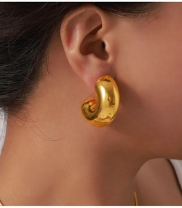 Macro view of 18K gold plated C-shaped chunky hoop earrings with a mirror finish