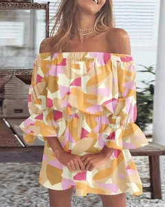 Detail van de off-shoulder halslijn en ruches op een mini-jurk met geometrische print