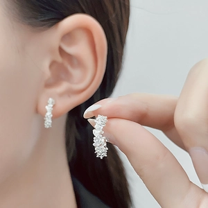 Macro detail of silver irregular lava texture earrings with molten metal finish for women