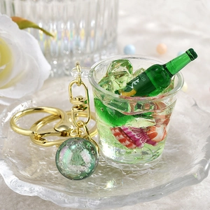 Nahaufnahme eines DIY-Bierkrug-Schlüsselanhängers mit grüner Flüssigkeit und Miniflasche