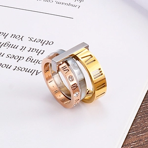 Macro detail of triple-layered titanium rings with Roman numerals and crystals