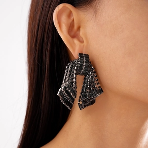 Close-up of elegant black crystal bow earrings with multi-strand fringe on model