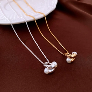 Close-up of irregular freshwater pearl pendants on 18k gold and silver box chains