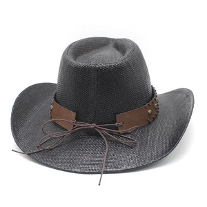 Detail of black straw cowboy hat featuring brown leather band with metal rivets