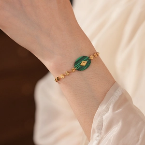 Détail d'un bracelet vintage en or orné d'une pierre de malachite verte ovale