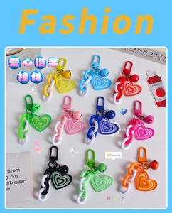 Close-up of colorful heart chain keychains with acrylic pendants and matching bells