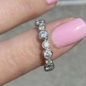 Detail of silver eternity ring with bezel-set cubic zirconia on hand for daily wear