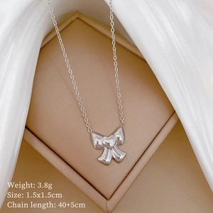 Close-up of silver bow pendant necklace with heart detail and 40+5cm chain specs