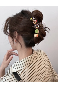 Detail of bear donut hair claw clip showing cute resin dessert charms on brown translucent clip