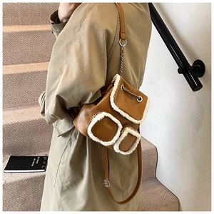 Brown leather backpack with white faux fur trim and elegant metal chain details