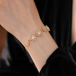 Detail of vintage gold flower bracelet with white zircon and adjustable drawstring chain
