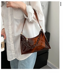 Detail of brown transparent jelly shoulder bag with thick link chain and gold zipper