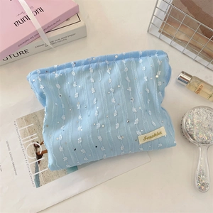 Gros plan sur la trousse de maquillage en dentelle bleu clair avec paillettes argentées