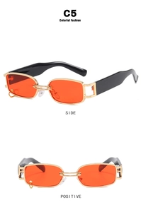 Detail of orange rectangular sunglasses with gold metal frame and side hollow geometry