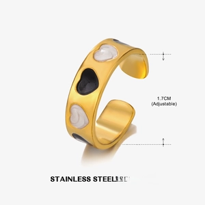 Detail view of adjustable stainless steel ring with black and white enamel heart patterns